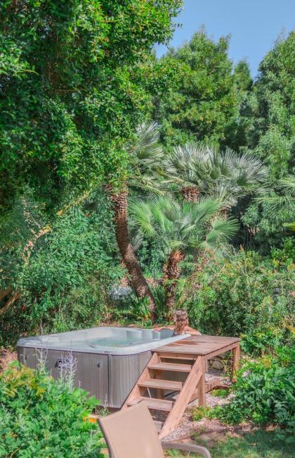 Giardino lussureggiante con vasca idromassaggio immersa nel verde.