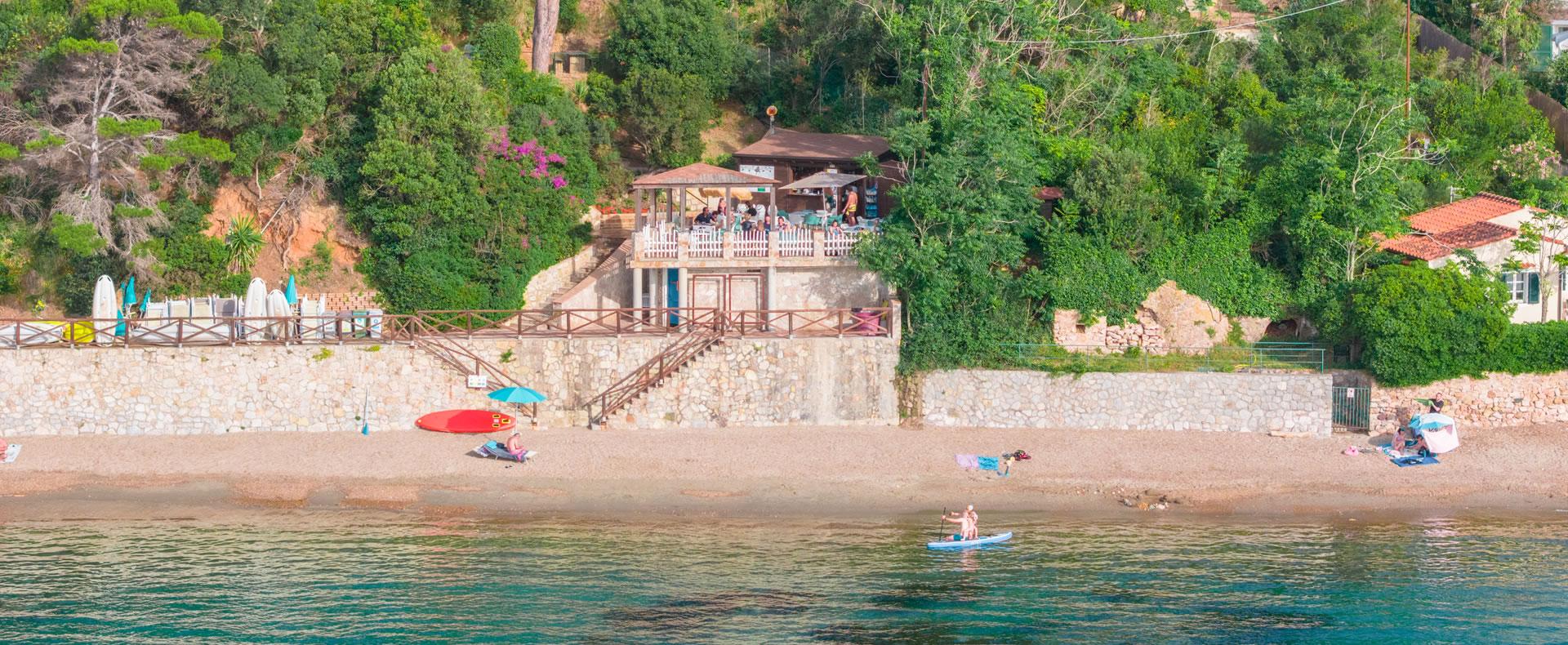 Peaceful beach, calm sea, cozy bar nestled in greenery.